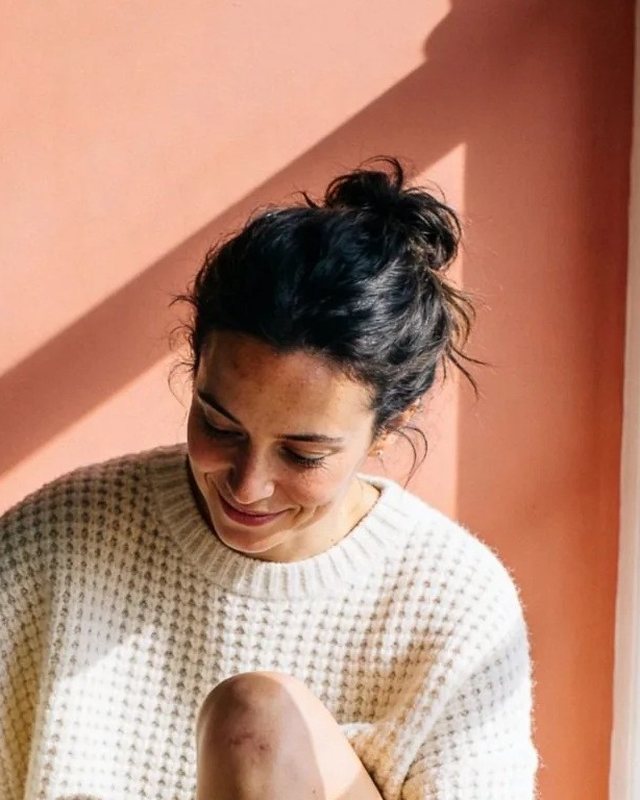A woman at home, looking down, thinking