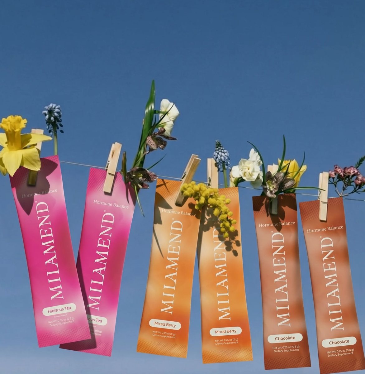 Milamend stick packs hung on a line with spring flowers